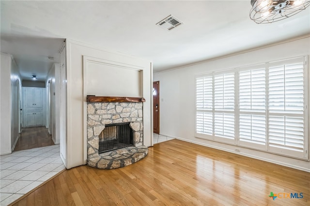 unfurnished living room with a stone fireplace and hardwood / wood-style floors