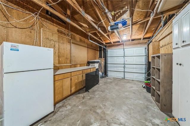 garage with white refrigerator and a garage door opener