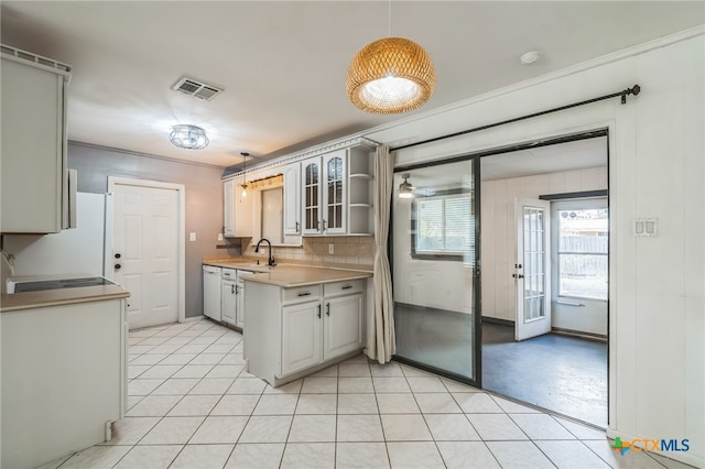 kitchen with tasteful backsplash, pendant lighting, white refrigerator, and sink