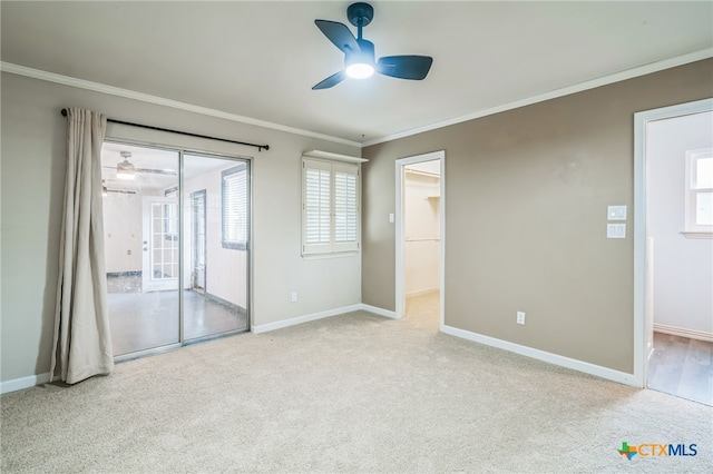 carpeted spare room featuring ceiling fan and crown molding