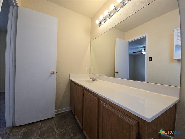 bathroom with ceiling fan, vanity, and baseboards