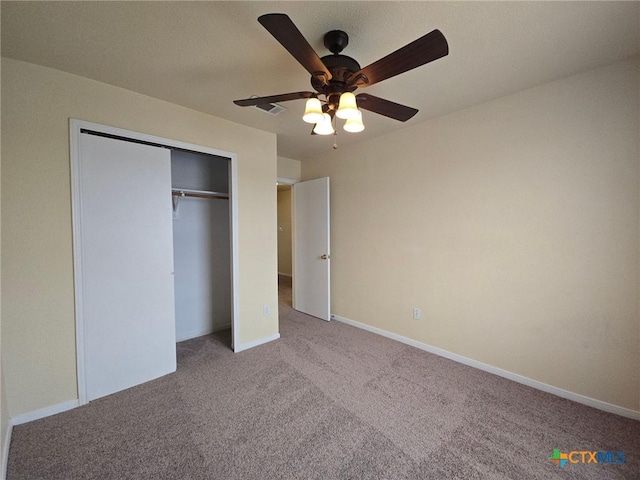 unfurnished bedroom with baseboards, ceiling fan, a closet, and light colored carpet