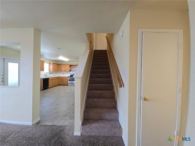 staircase featuring carpet flooring and baseboards