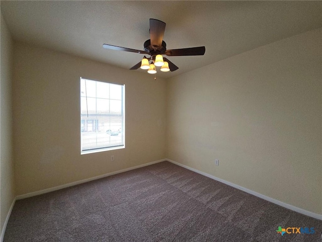 carpeted spare room featuring ceiling fan and baseboards