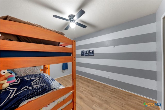bedroom featuring baseboards, ceiling fan, and wood finished floors