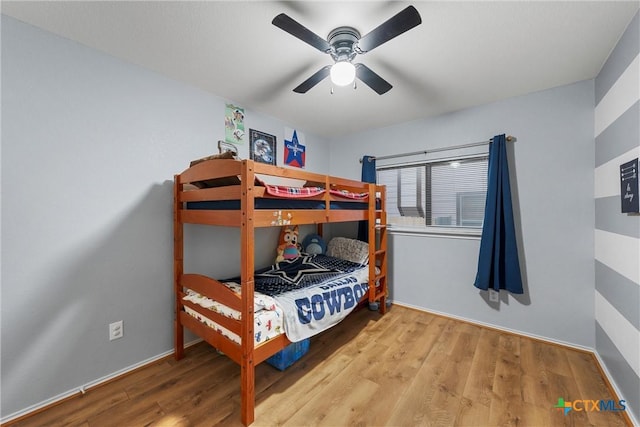 bedroom featuring baseboards, ceiling fan, and wood finished floors