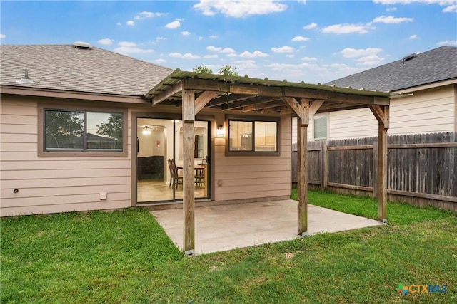 back of house with a patio, a shingled roof, a yard, and fence private yard
