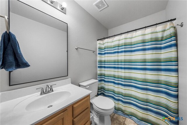 bathroom with visible vents, a shower with shower curtain, toilet, and vanity