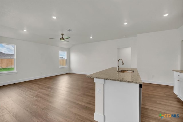 kitchen with white cabinetry, sink, a kitchen island with sink, and hardwood / wood-style flooring