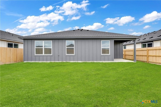 rear view of house featuring a lawn and a patio