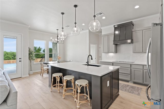 301 Canyon Oaks Rd, Troy, TX 76579 - kitchen featuring visible vents, black electric cooktop, a sink, freestanding refrigerator, and custom exhaust hood