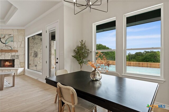 301 Canyon Oaks Rd, Troy, TX 76579 - dining space featuring crown molding, wood finished floors, a healthy amount of sunlight, and a stone fireplace
