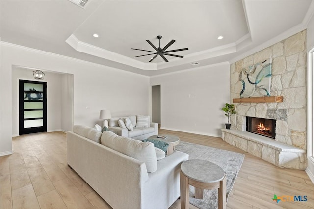 301 Canyon Oaks Rd, Troy, TX 76579 - living room featuring crown molding, a fireplace, a tray ceiling, a ceiling fan, and light wood finished floors
