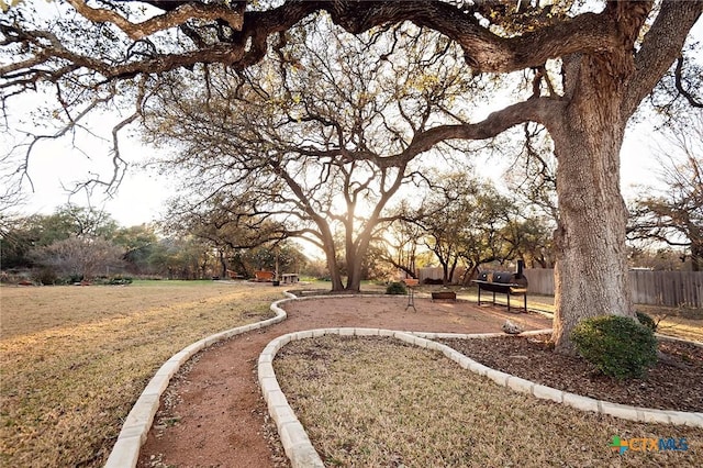 view of home's community with a lawn and fence