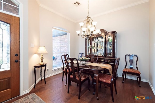 dining area with visible vents, crown molding, dark wood-type flooring, baseboards, and a notable chandelier