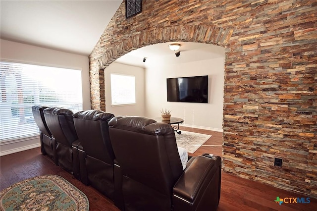 cinema room featuring lofted ceiling, wood finished floors, and baseboards