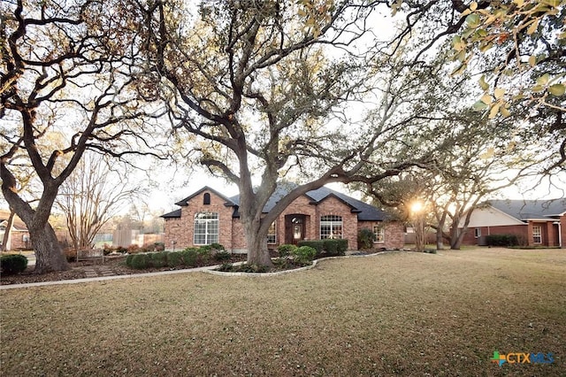 view of front of home featuring a front lawn and brick siding