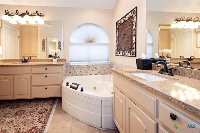 bathroom featuring tile patterned floors, a jetted tub, two vanities, and a sink