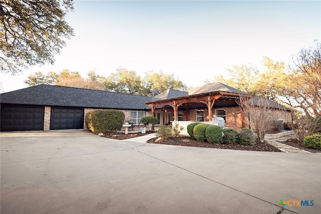 view of front of property featuring concrete driveway, an attached garage, and brick siding