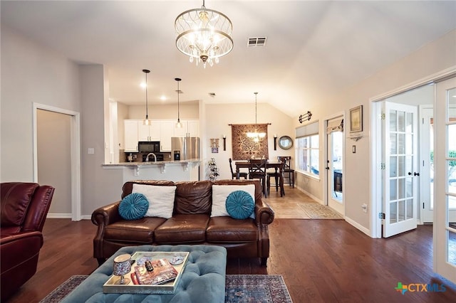 living room with baseboards, visible vents, dark wood-type flooring, vaulted ceiling, and a notable chandelier