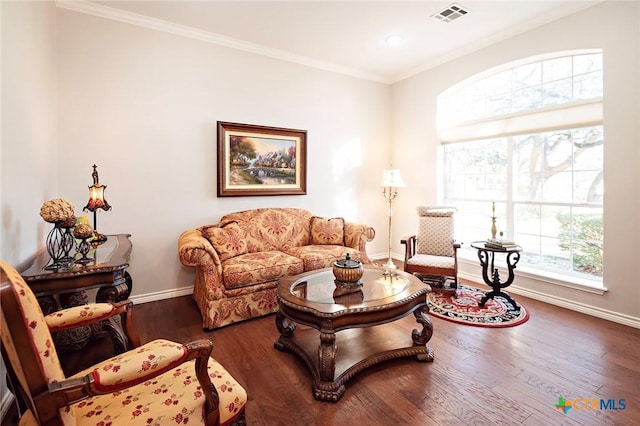 living room featuring visible vents, wood finished floors, baseboards, and ornamental molding