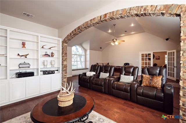 cinema room featuring visible vents, lofted ceiling, ceiling fan, and dark wood-style flooring