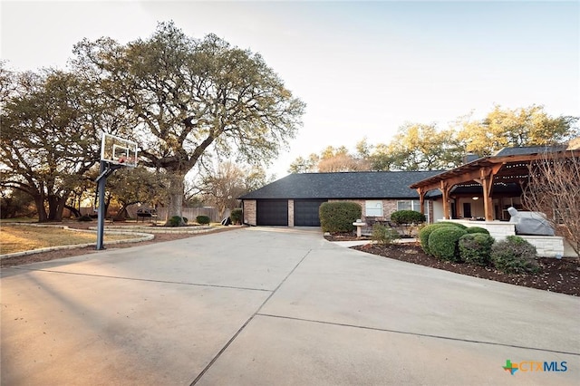 view of side of property featuring concrete driveway and a garage