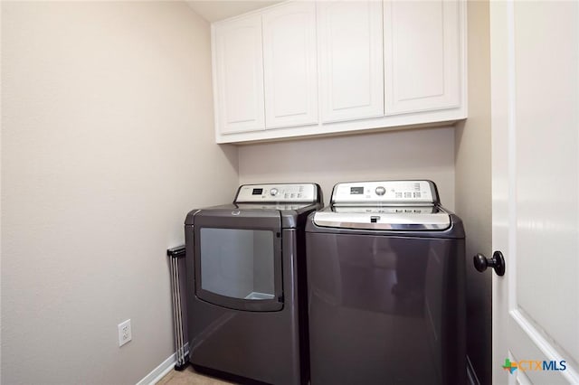 laundry area with washing machine and clothes dryer, cabinet space, and baseboards