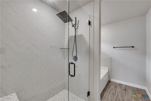 7611 Iridium Dr, Killeen, TX 76542 - full bath featuring a garden tub, a shower stall, wood finished floors, and baseboards