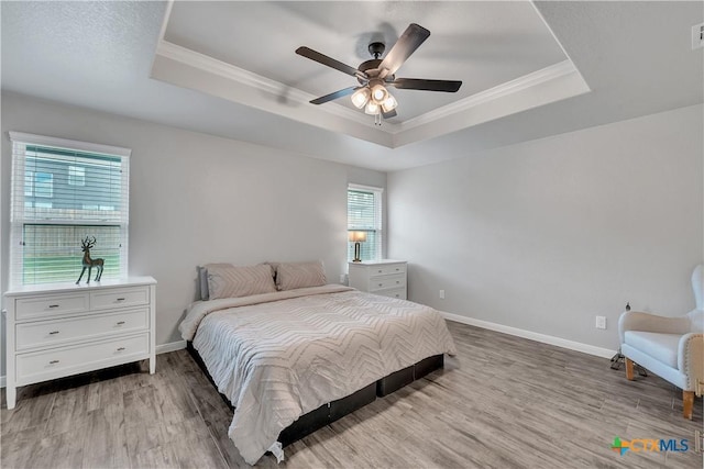 7611 Iridium Dr, Killeen, TX 76542 - bedroom with a tray ceiling, crown molding, wood finished floors, baseboards, and a ceiling fan