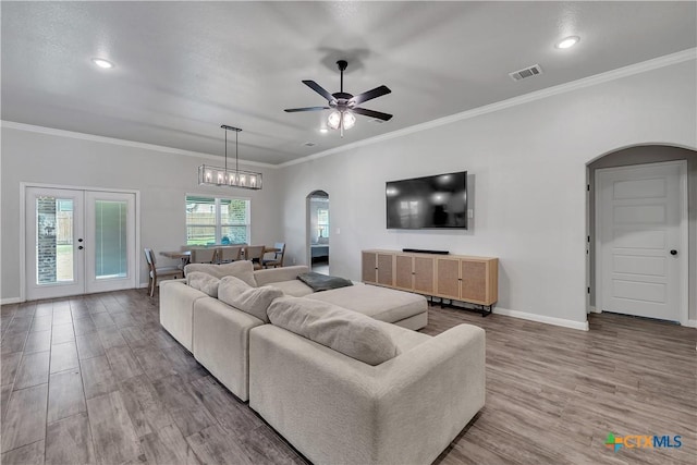 7611 Iridium Dr, Killeen, TX 76542 - living area featuring arched walkways, wood finished floors, a ceiling fan, baseboards, and crown molding
