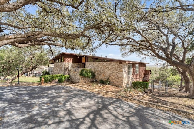 667 Fredericksburg Rd, New Braunfels, TX 78130 - view of side of home featuring a gate, stone siding, and fence