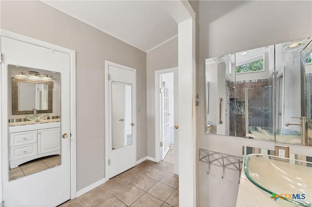 667 Fredericksburg Rd, New Braunfels, TX 78130 - full bathroom featuring vanity, tile patterned floors, baseboards, and vaulted ceiling