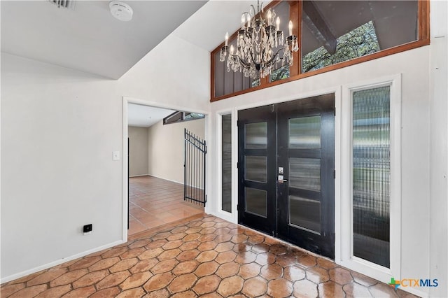 667 Fredericksburg Rd, New Braunfels, TX 78130 - entryway with a notable chandelier, high vaulted ceiling, french doors, tile patterned flooring, and baseboards
