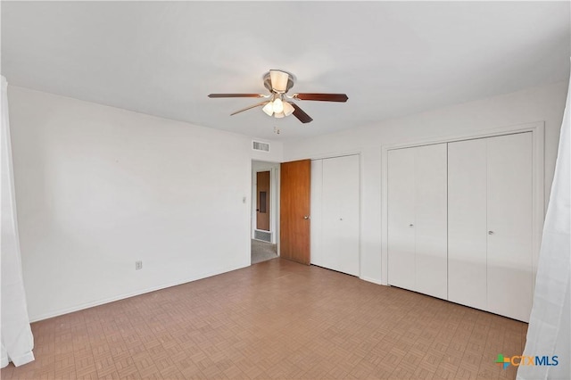 667 Fredericksburg Rd, New Braunfels, TX 78130 - unfurnished bedroom featuring visible vents, baseboards, two closets, and a ceiling fan