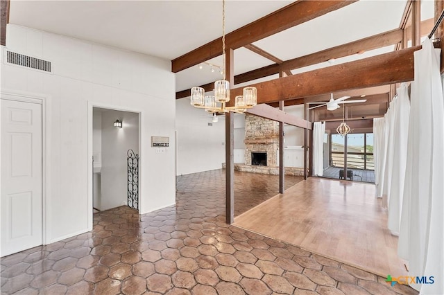 667 Fredericksburg Rd, New Braunfels, TX 78130 - unfurnished living room with beam ceiling, visible vents, ceiling fan with notable chandelier, and a fireplace