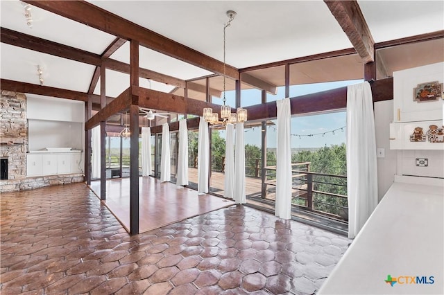 667 Fredericksburg Rd, New Braunfels, TX 78130 - unfurnished dining area with expansive windows, a notable chandelier, a fireplace, and vaulted ceiling with beams