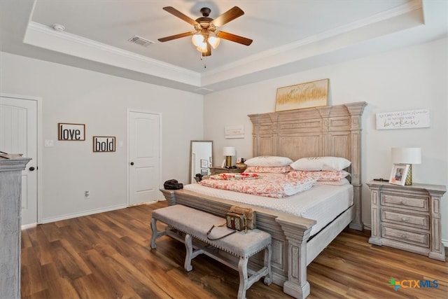 bedroom featuring a tray ceiling, crown molding, ceiling fan, and dark hardwood / wood-style floors