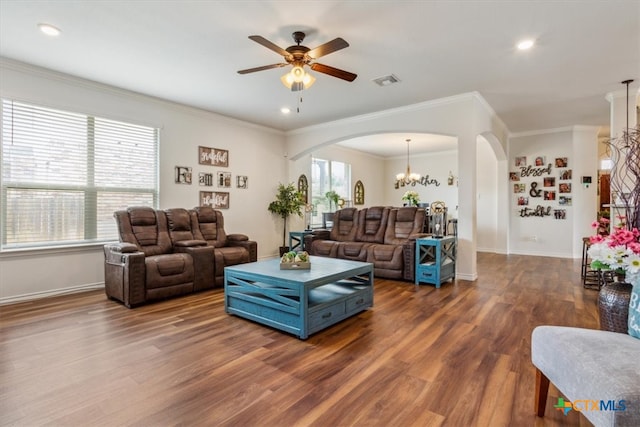 living room featuring ornamental molding, ceiling fan with notable chandelier, and dark wood-type flooring