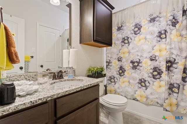 full bathroom featuring vanity, shower / bath combo with shower curtain, tile patterned flooring, and toilet