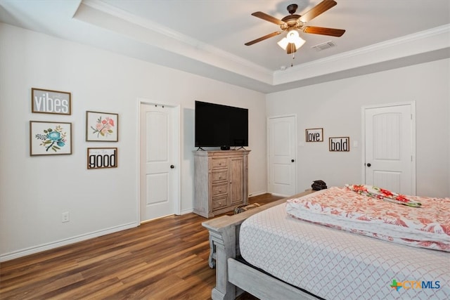 bedroom with a raised ceiling, dark wood-type flooring, ceiling fan, and crown molding