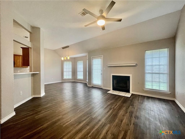1715 Ramona Cir, San Marcos, TX 78666 - unfurnished living room featuring a ceiling fan, lofted ceiling, dark wood finished floors, and a fireplace with flush hearth