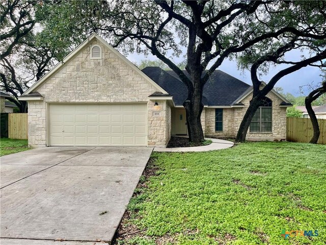 1715 Ramona Cir, San Marcos, TX 78666 - view of front of home featuring stone siding, an attached garage, driveway, and roof with shingles