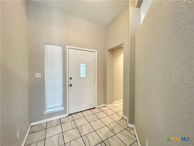 1715 Ramona Cir, San Marcos, TX 78666 - entrance foyer featuring light tile patterned floors and a textured wall
