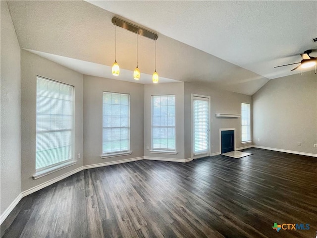 1715 Ramona Cir, San Marcos, TX 78666 - unfurnished living room with lofted ceiling, dark wood-type flooring, a fireplace with flush hearth, a textured ceiling, and a ceiling fan