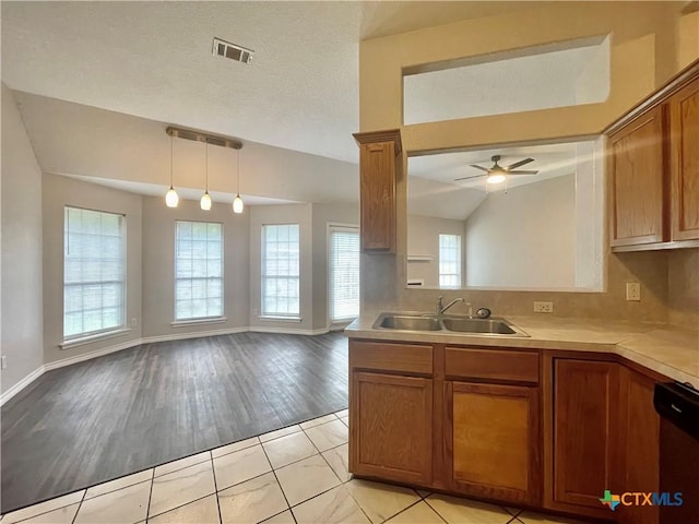 1715 Ramona Cir, San Marcos, TX 78666 - kitchen with brown cabinets, dishwasher, light countertops, open floor plan, and ceiling fan