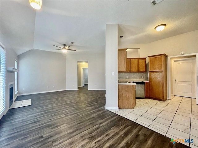 1715 Ramona Cir, San Marcos, TX 78666 - kitchen with brown cabinets, light wood-style flooring, a ceiling fan, open floor plan, and light countertops