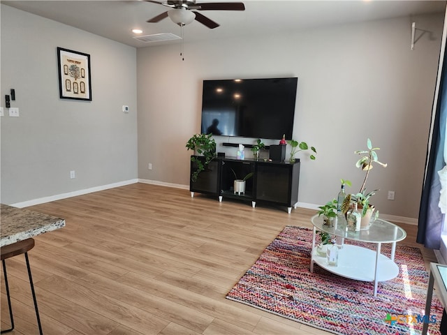 living room with wood-type flooring and ceiling fan