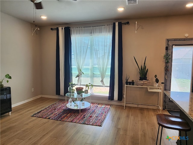 living area featuring ceiling fan and light hardwood / wood-style flooring