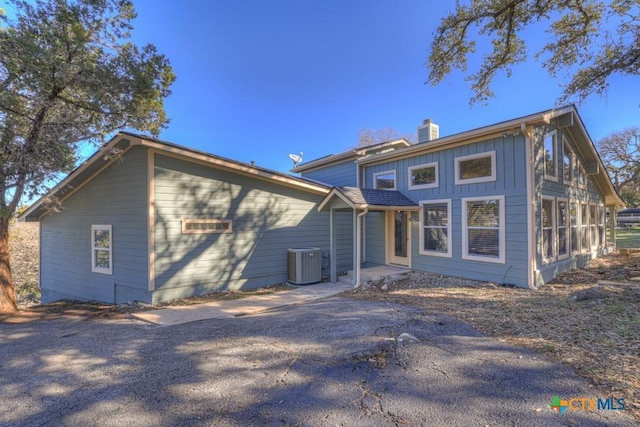 rear view of house featuring cooling unit